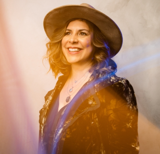 A woman wearing a hat and smiling for the camera.