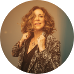 A woman with curly hair is posing for the camera.